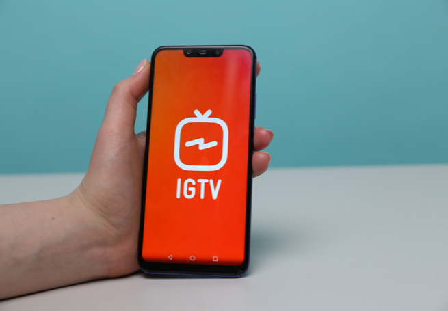 Uma mão segurando um celular com o app IGTV